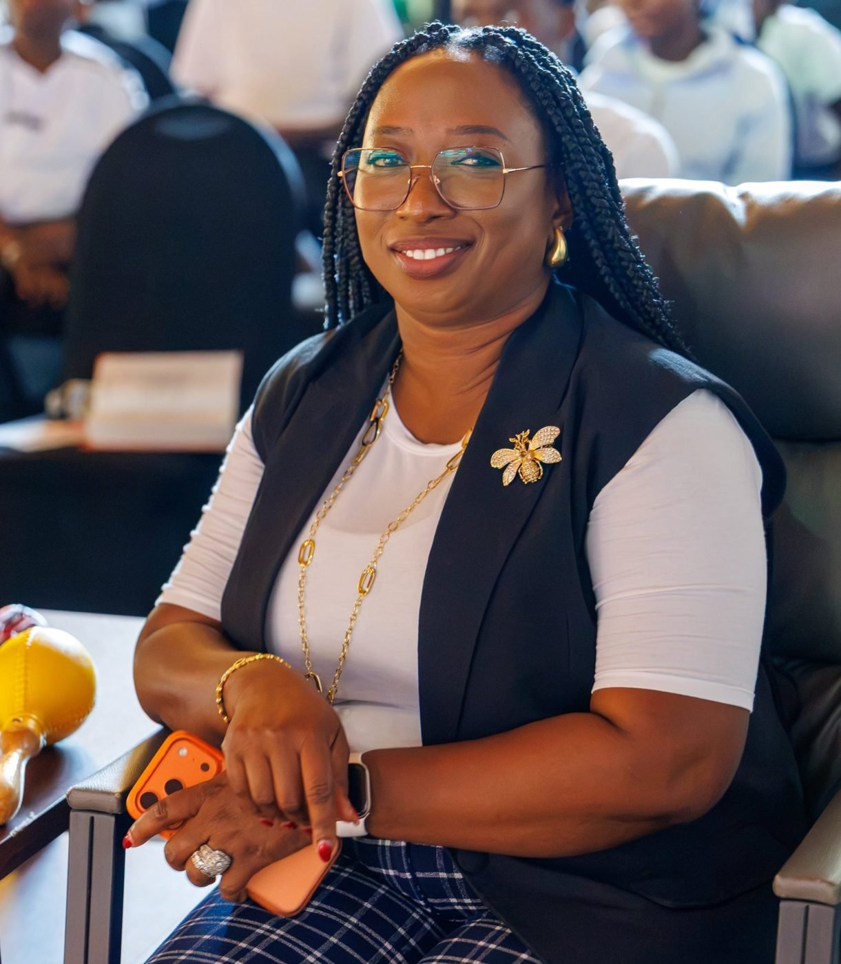 Kemi smiling warmly while seated among women at a church gathering
